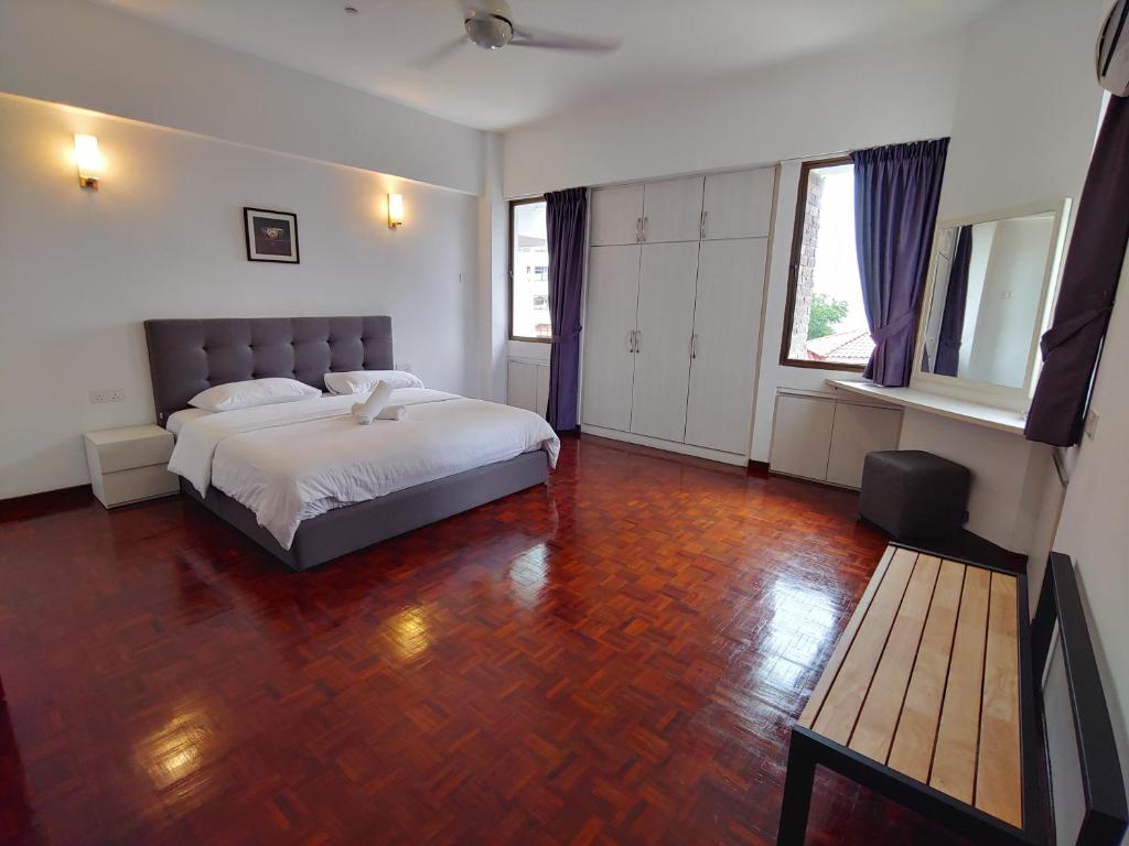 乔治市新关仔角城公寓的一间卧室配有一张床,铺有木地板