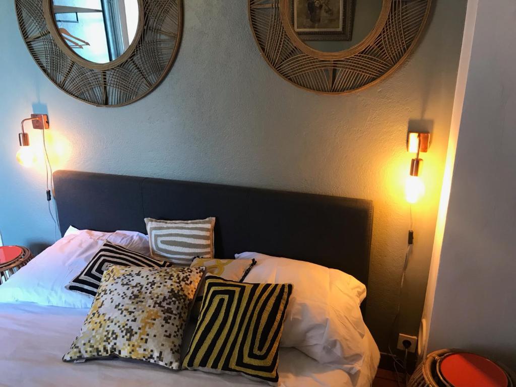 巴斯蒂亚Chambre Rose的一间卧室配有一张带枕头的床和两面镜子