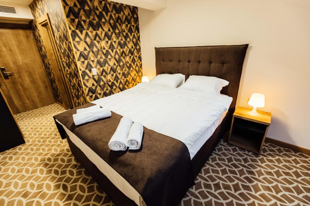 贝尔格莱德Hotel Livnica的一间卧室配有一张大床和毛巾