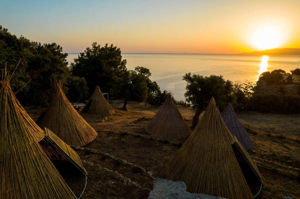 尼奥克瑞奥Aphrodite Family Eco Camping的一组帐篷,背景是日落