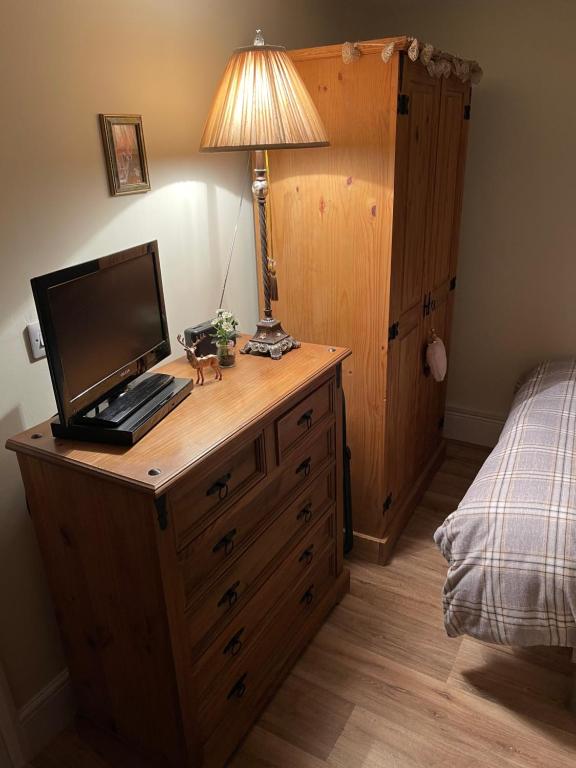 Thornton CurtisDeer Lodge的一间卧室配有木制梳妆台和电脑