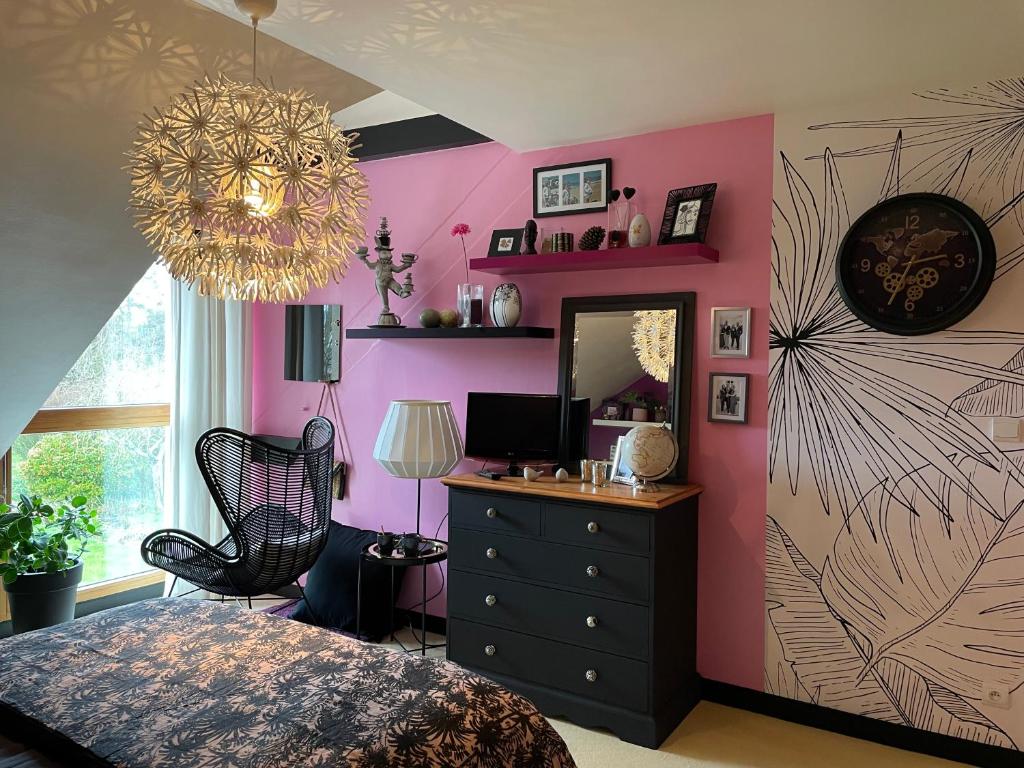 格朗维尔Chez Béa的一间卧室配有粉红色的墙壁、梳妆台和镜子