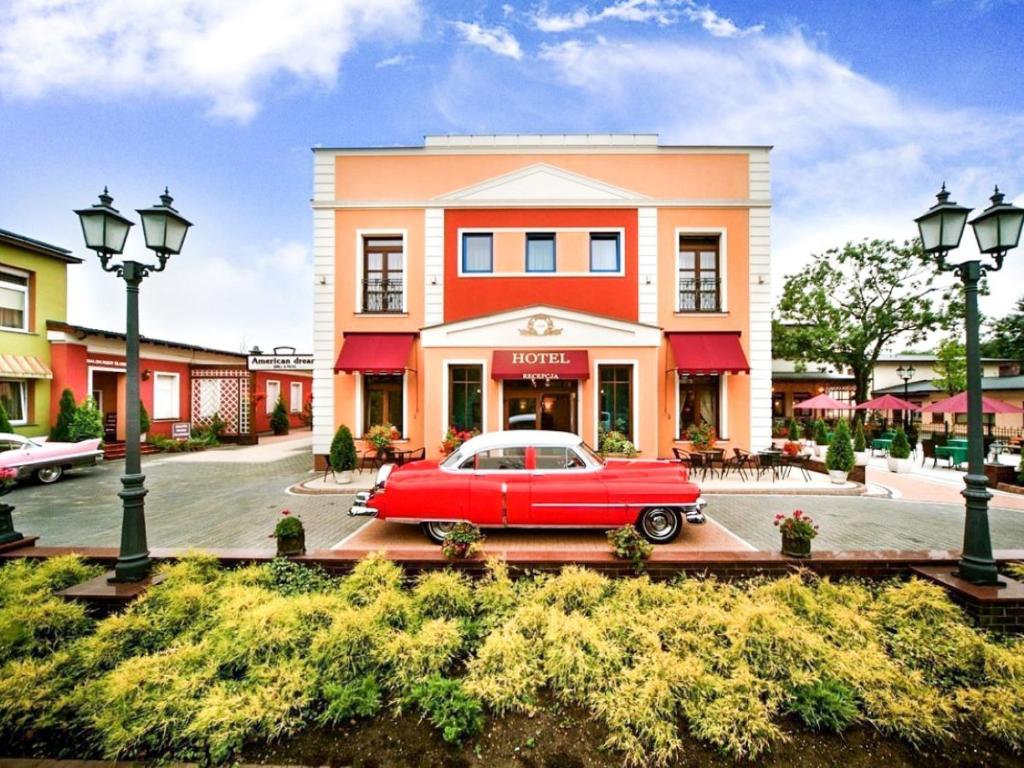 弗罗茨瓦夫Hotel Stara Garbarnia的停在大楼前的红色汽车