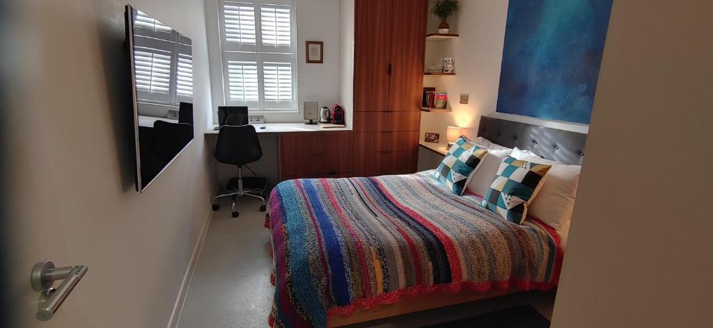 伦敦Comfortable Room With Ensuite的一间卧室配有一张带彩色毯子的床