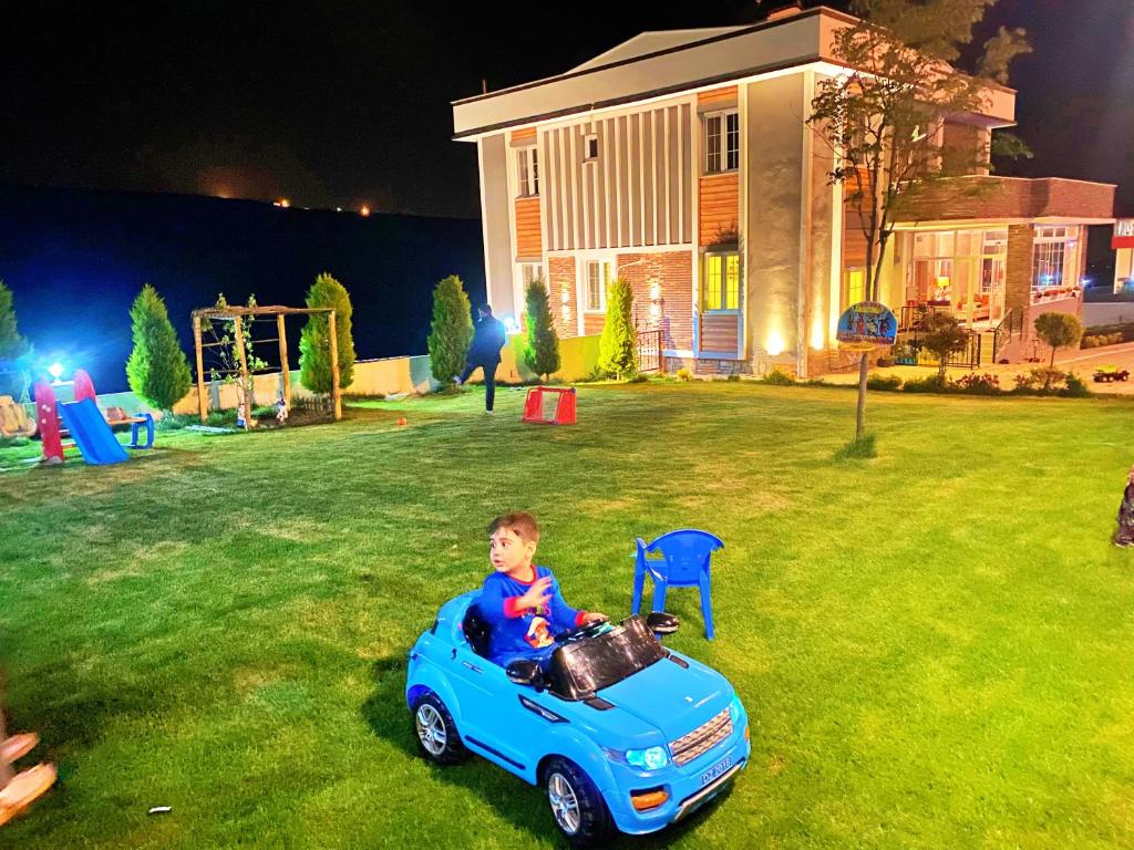 萨姆松Öztürk Farm House的在一个院子里骑玩具车的男孩