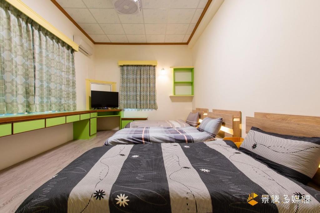 关山镇伯特利民宿的一间卧室配有两张床和一台平面电视