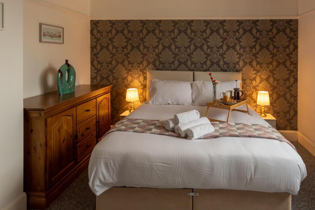 滨海戈尔斯顿Trafalgar House的一间卧室配有一张床,上面有两条毛巾
