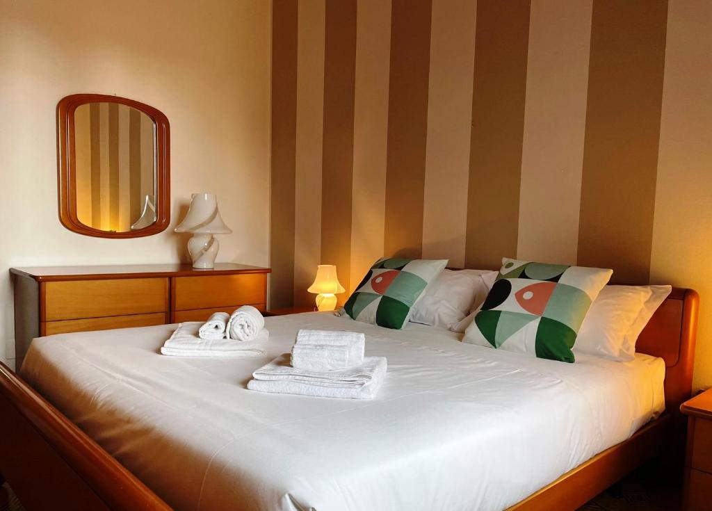 塞斯托-圣乔凡尼Apartment Station Sesto - Affitti Brevi Italia的一间卧室配有带毛巾和镜子的床