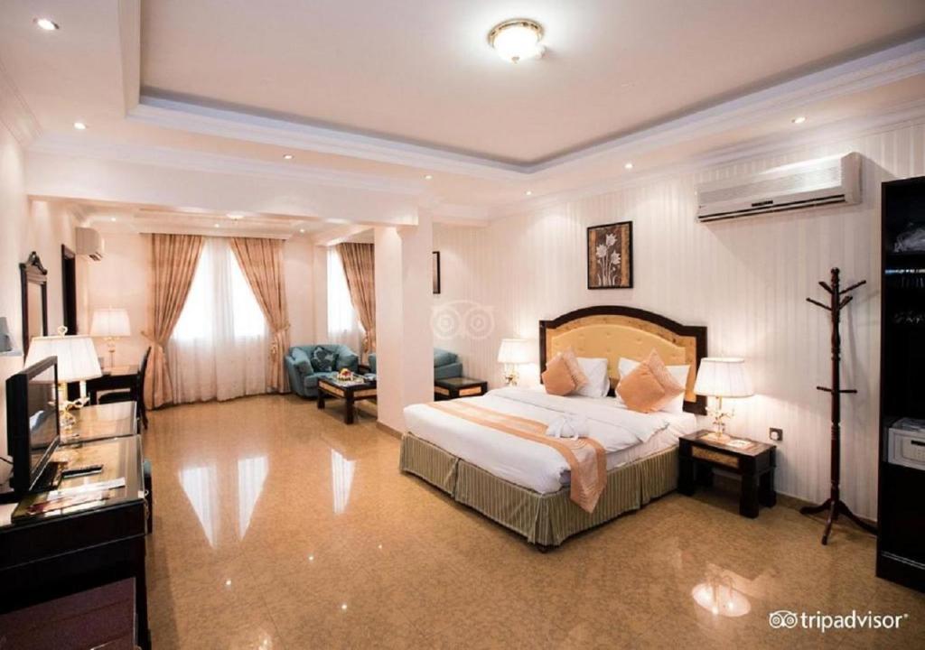 马斯喀特Garden Hotel Muscat By Royal Titan Group的一间带大床的卧室和一间客厅
