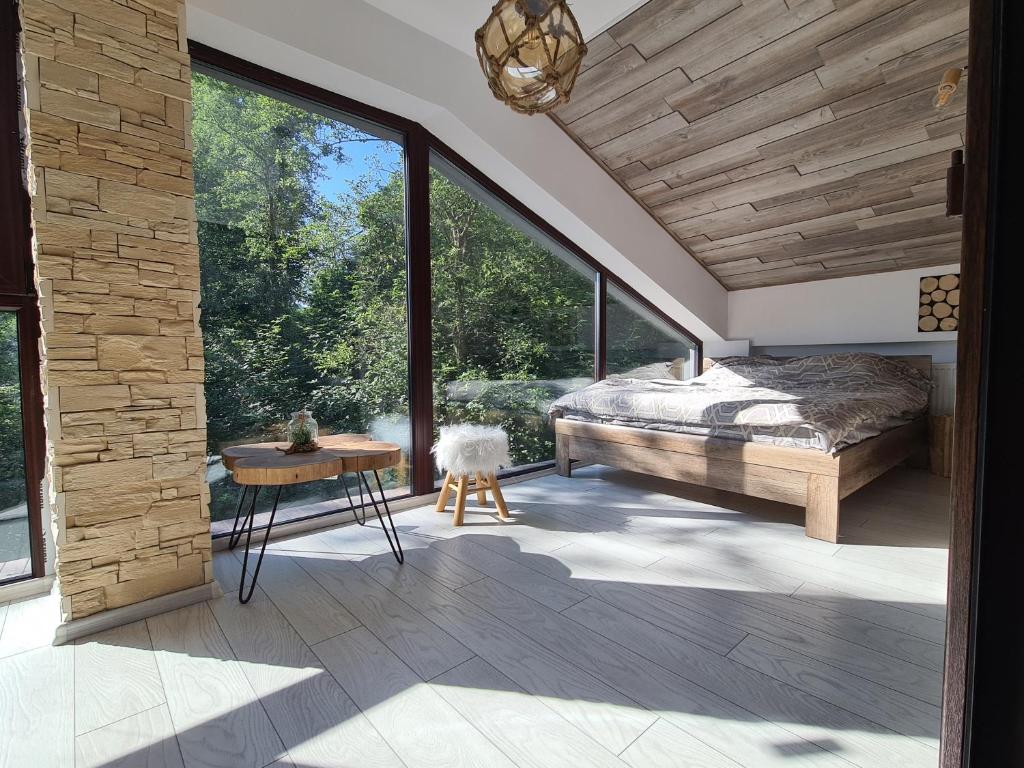 普雷代亚尔Penthouse luxury Predeal View的一间卧室设有一张床和一个大窗户