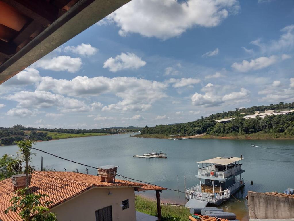卡皮托利乌Suítes Ponta do Sol (Trator)的河里河里,水里有船