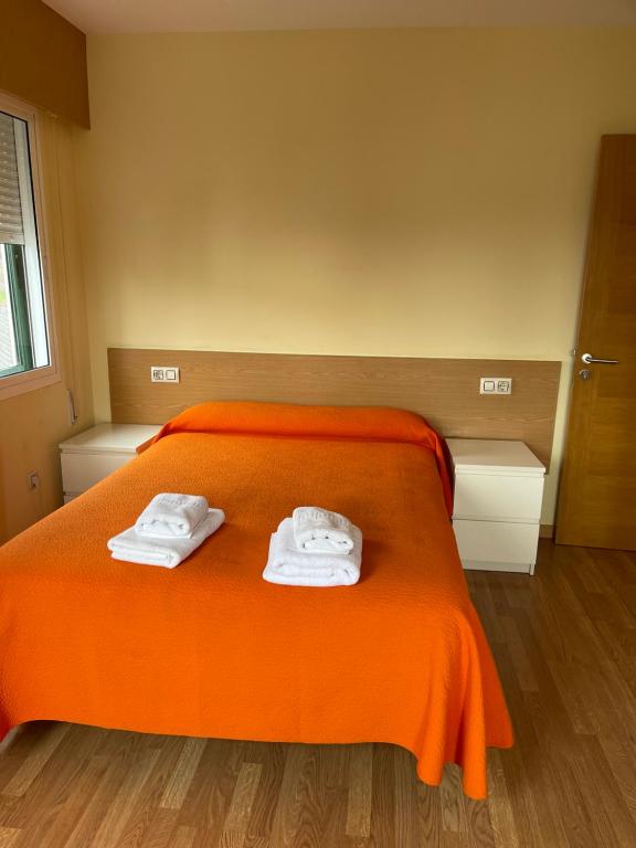 PortaApartment Lecer 7 - 2nd floor的一间卧室配有橙色床和毛巾