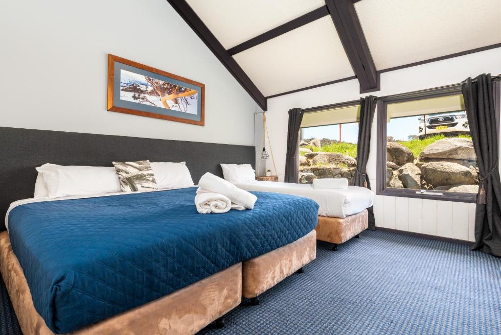佩里舍峡谷Snowy Gums Smiggins的一间卧室设有两张床和窗户。