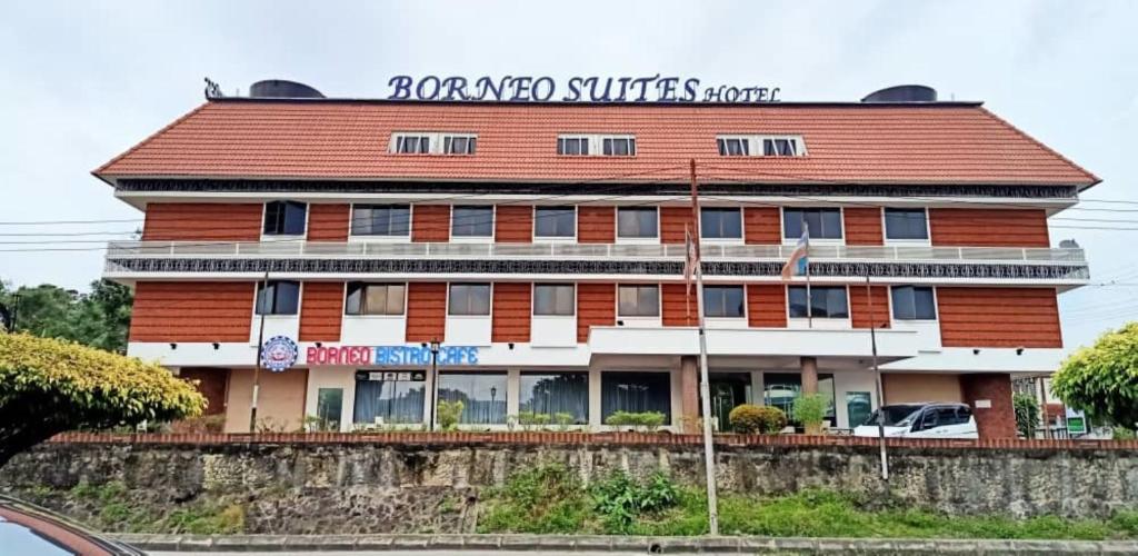 哥打京那巴鲁Super OYO 90464 Borneo Suites Hotel的一座红色和白色的建筑,上面有标志