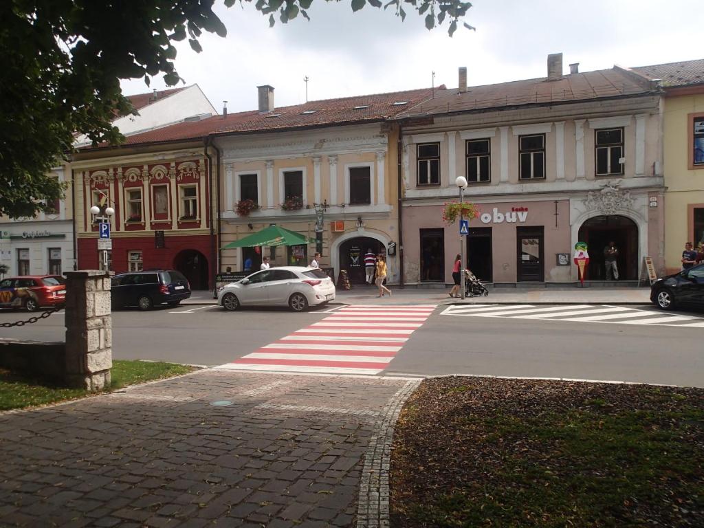 旧柳博夫尼亚Penzión a Reštaurácia u Jeleňa的一条城市街道,汽车停在大楼前