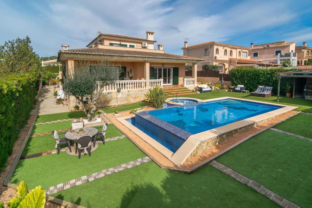 马拉特克西Joan Deia Escultor的一个带游泳池和房子的后院
