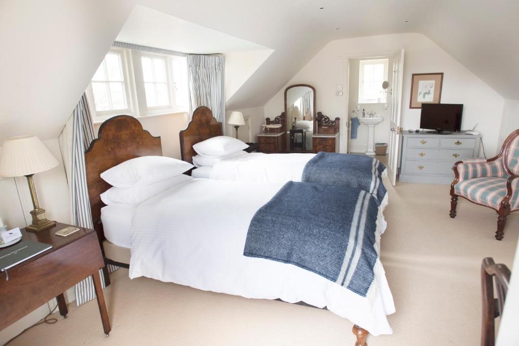 普尔伯勒The Countryside Annexe的卧室配有白色的床和蓝色毯子