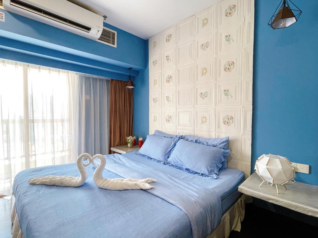 八打灵再也Sunway Resort Suite @ Sunway Pyramid Lagoon View的蓝色卧室里,两只天鹅坐在床上