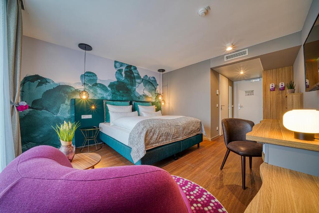 弗莱堡FourSide Hotel Freiburg的酒店客房设有一张床和一张紫色沙发