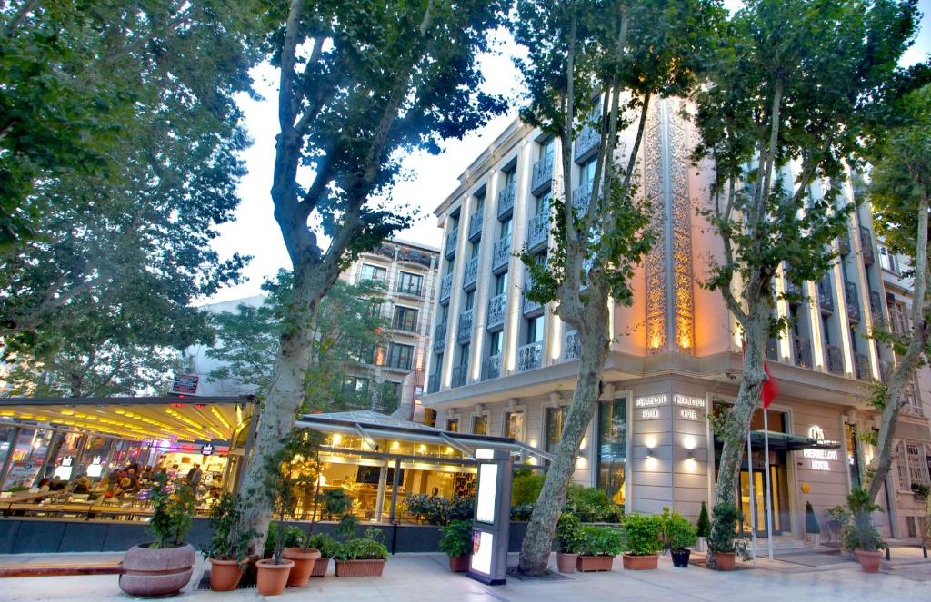 伊斯坦布尔Pierre Loti Hotel Old City- Special Category的一条树木繁茂的城市街道和一座建筑
