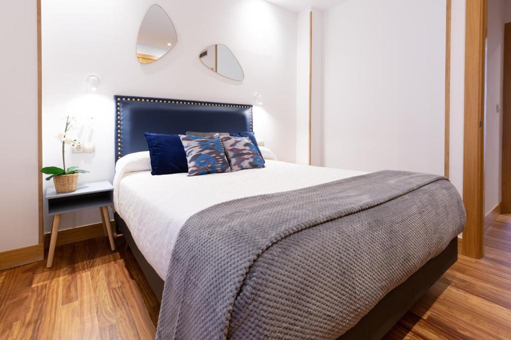 毕尔巴鄂Unamuno by Bilbao Living的一间卧室配有一张大床和蓝色床头板