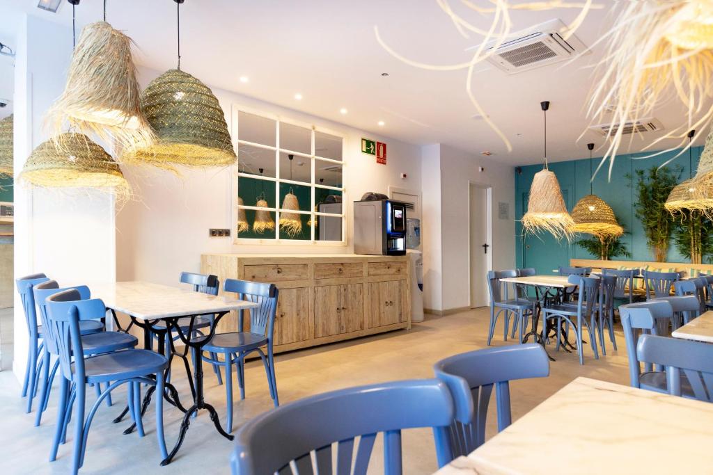 巴塞罗那Yomo Hostal BCN Port的一间设有蓝色桌椅的餐厅和一间厨房