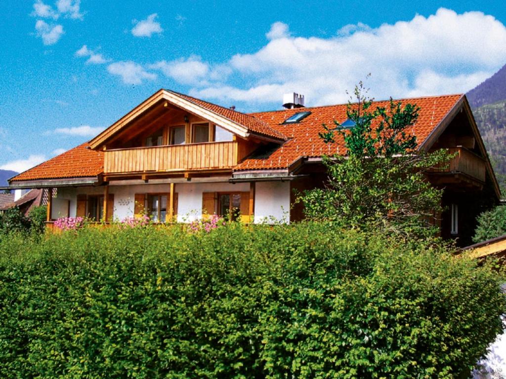 加尔米施-帕滕基兴Apartment Eberhorn by Interhome的一座带橙色屋顶和灌木的房子