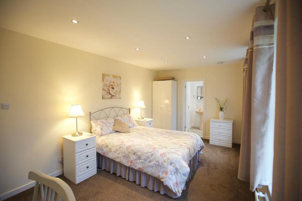 朗塞斯顿Waterfall Cottage的一间卧室配有一张带2个床头柜和2盏灯的床。