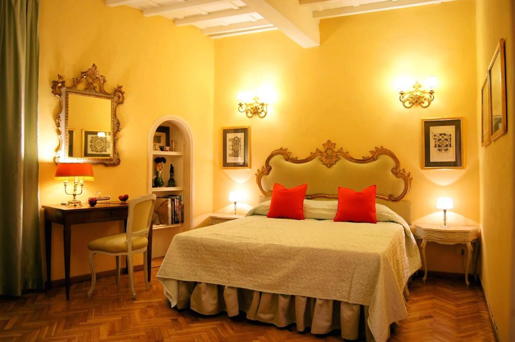 佛罗伦萨特来比欧酒店的一间卧室配有一张带两个红色枕头的床