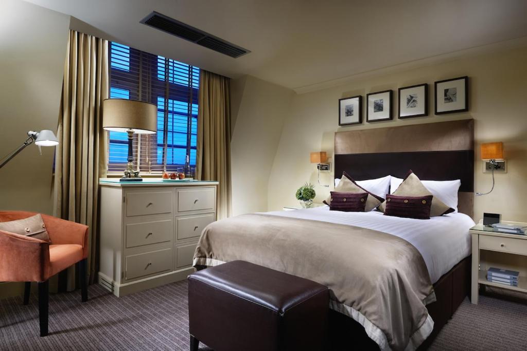 伦敦伦敦桥酒店的酒店客房带一张大床和一把椅子