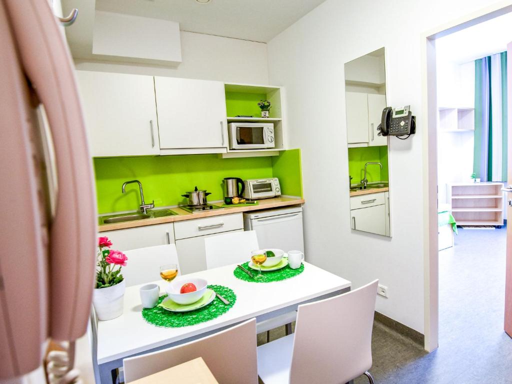 Sankt UlrichApartment smart living by Interhome的厨房配有白色橱柜和白色的桌椅