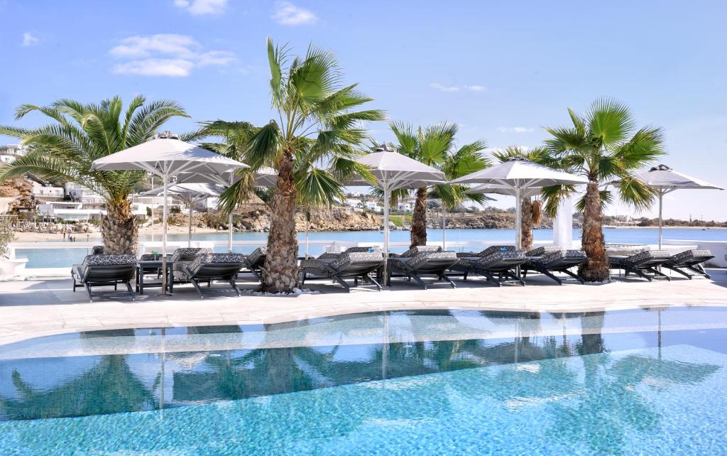 普拉迪斯亚罗斯佩蒂诺斯海滩酒店的一座棕榈树、椅子和遮阳伞的游泳池