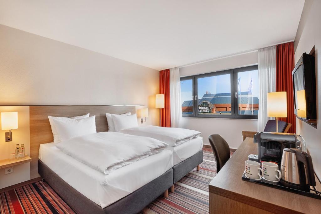 波鸿波鸿H+酒店的酒店客房配有一张床、一张书桌和一台电视。