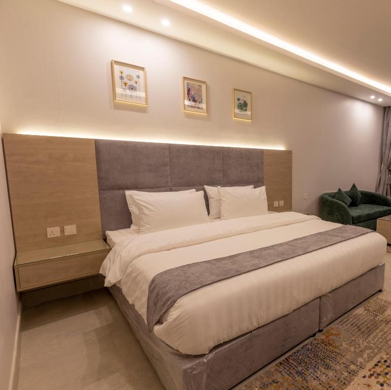 穆哈伊犁شقق أحلى الأيام للوحدات السكنية المفروشة的一间卧室配有一张大床和大床头板