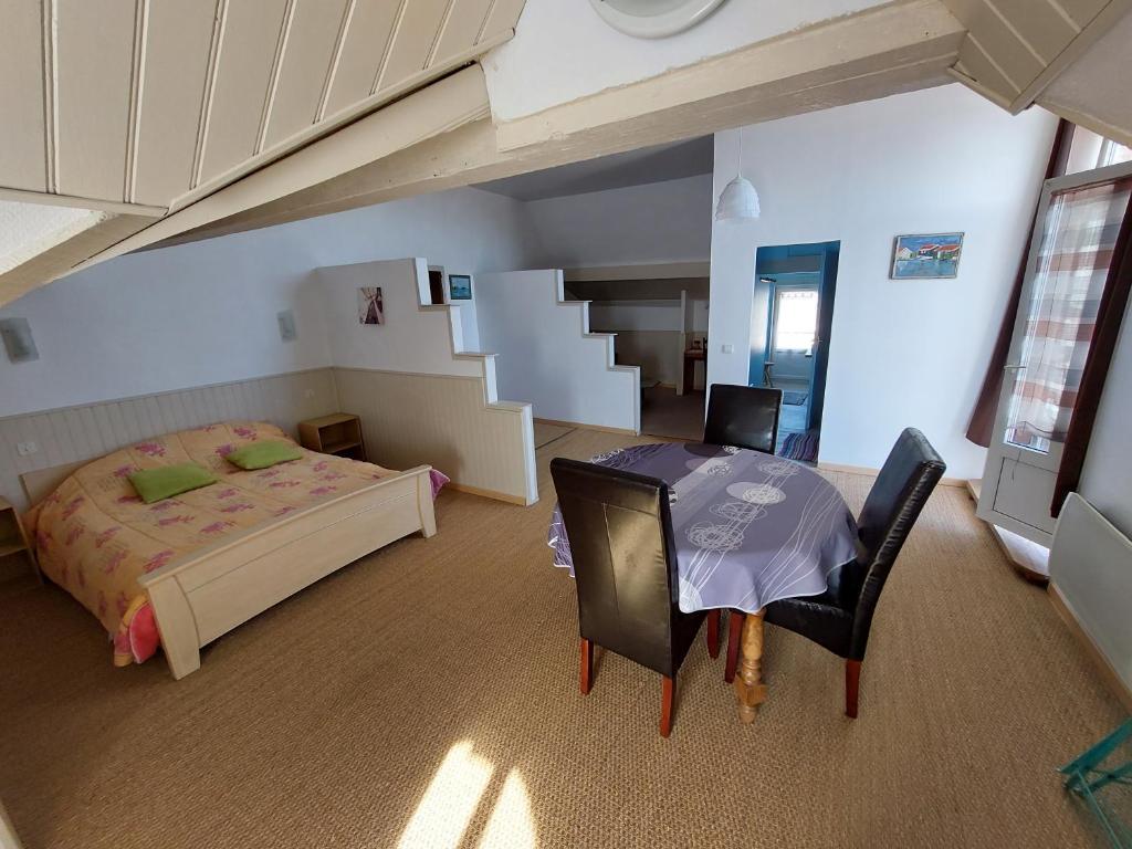 奥雷龙圣但尼因素莱尔旅馆的卧室配有一张床和一张桌子及椅子