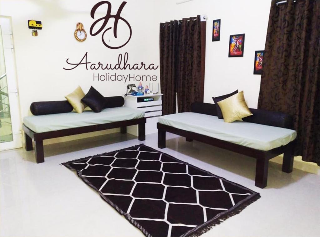 蓬蒂切里Aarudhara Holiday Home (A Home away from Home)的客厅配有两张沙发和地毯。