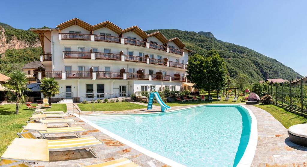 拉伊韦斯Hotel Garni Grüner Baum (Albero Verde)的大楼前设有游泳池的酒店