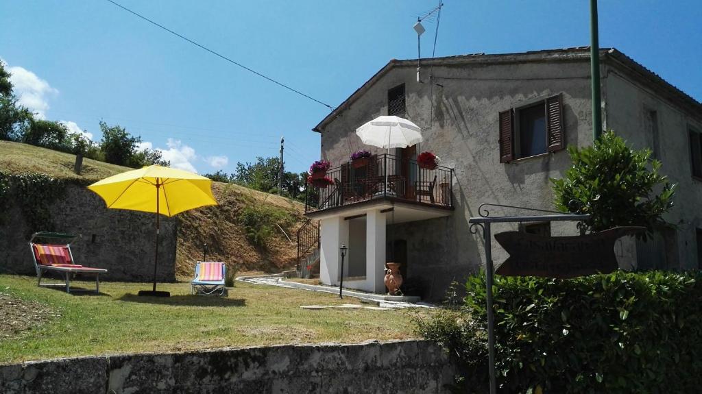 真加Oasi delle Gazze的带阳台和黄色遮阳伞的度假屋