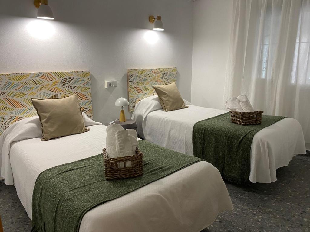 马贝拉Hostal Paco Marbella的酒店客房,配有两张带绿床单的床