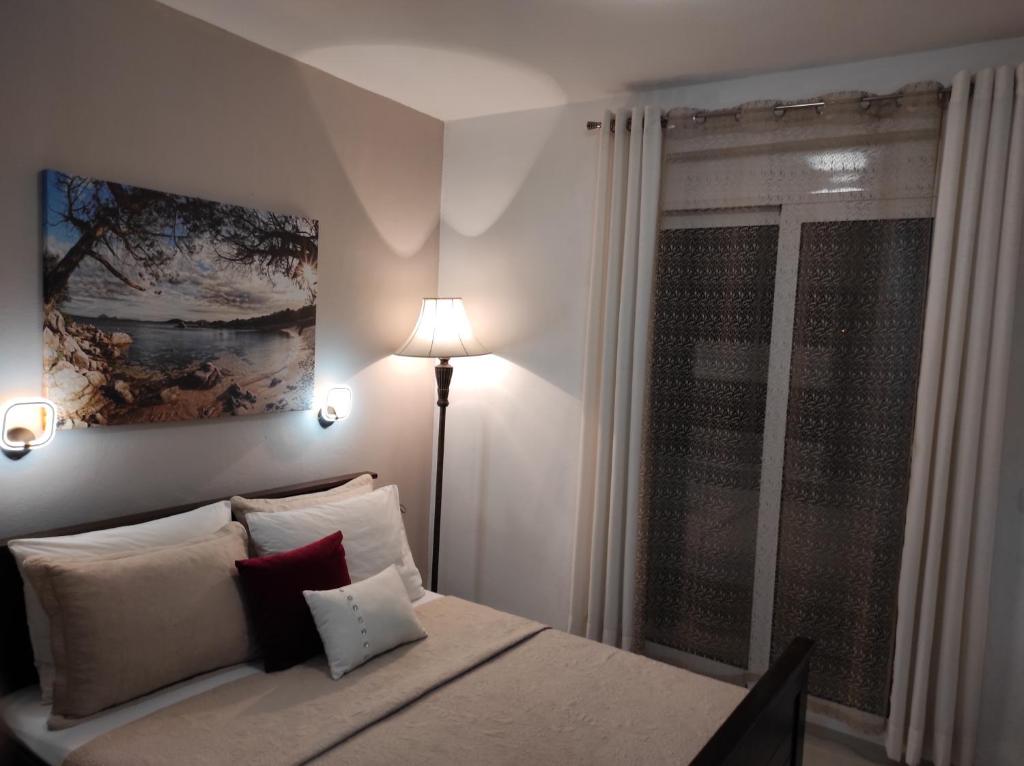 乌尔齐尼Guest House AGA的一间卧室配有带枕头和台灯的床