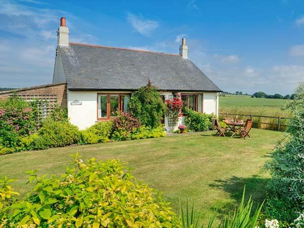 BowsdenBarmoor Ridge的一座白色的小房子,设有花园和庭院