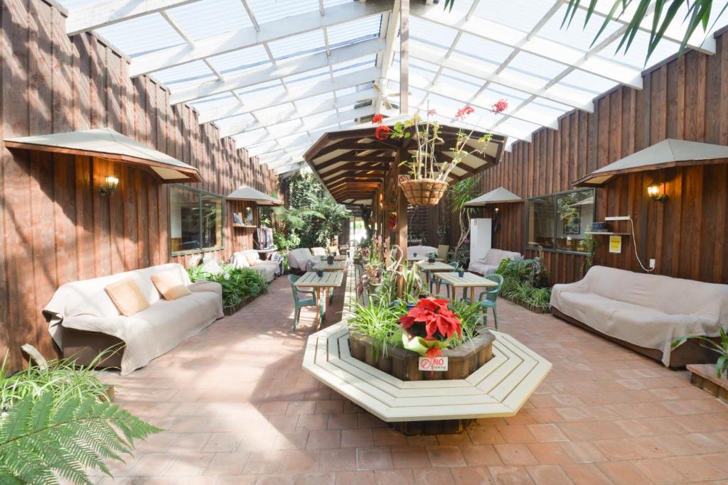 哈斯特原野背包客旅舍的庭院设有带沙发和桌子的温室。