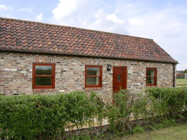 约克Lodge Cottage的砖屋,有红色的窗户和栅栏