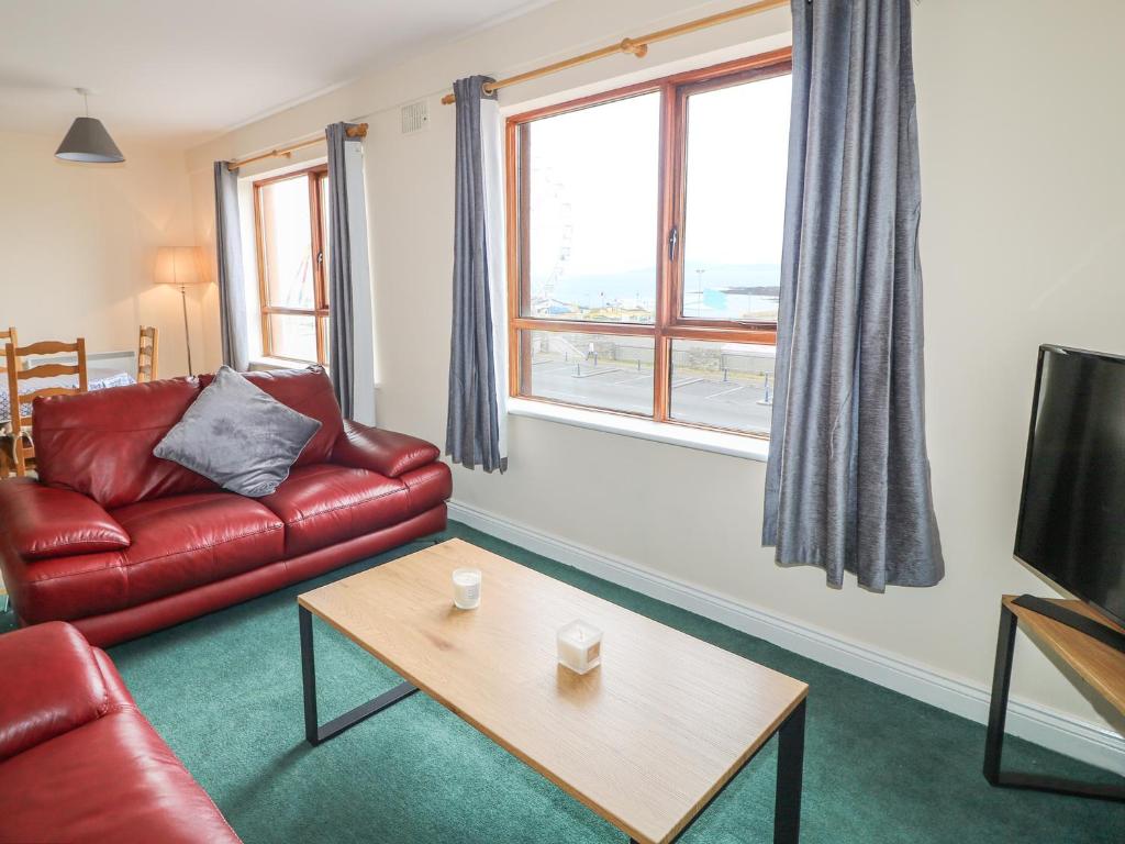 班多伦Apartment 42的客厅配有红色皮革沙发和茶几
