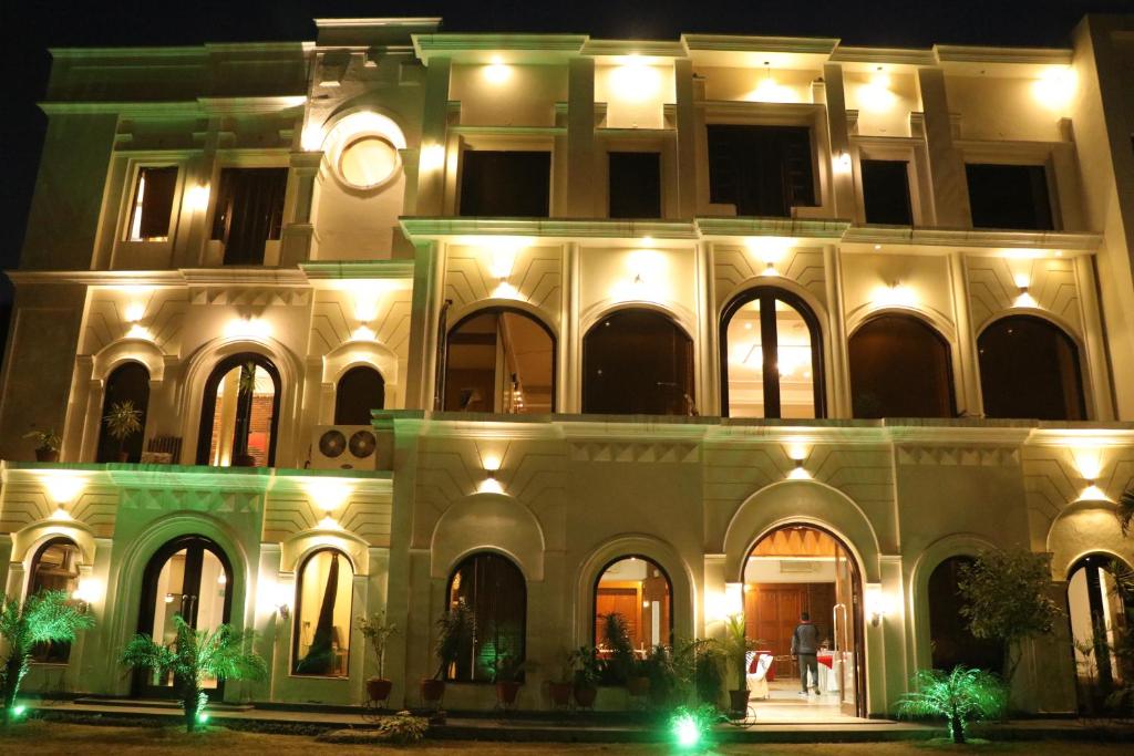 伯蒂亚拉Hotel Pushap Palace的一座建筑,晚上在它旁边有一个钟