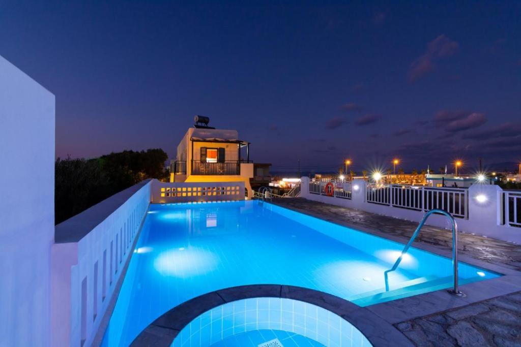 赫索尼索斯Okirroi Villas Chersonissos的一座游泳池,晚上与大楼相连