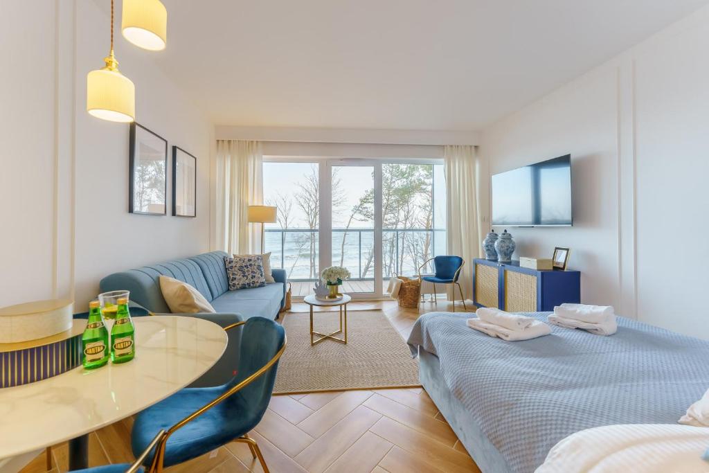 尤斯托尼莫斯基Sunnyway Apartment的客厅配有两张床和一张桌子