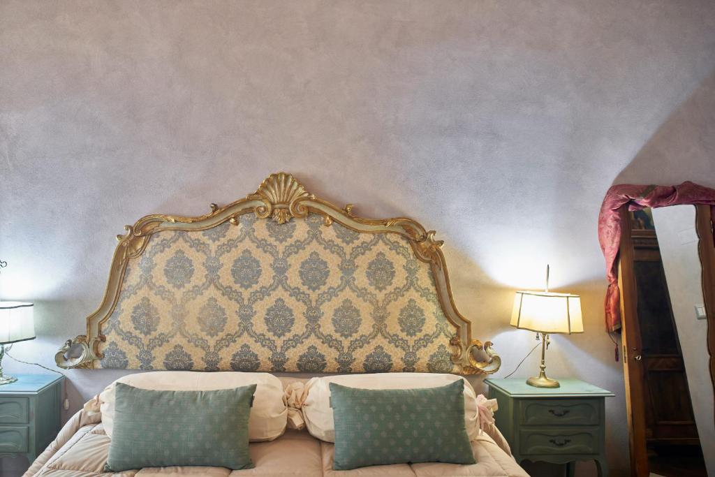 锡耶纳Alla Scala 1746的一张带华丽床头板和2晚台的床