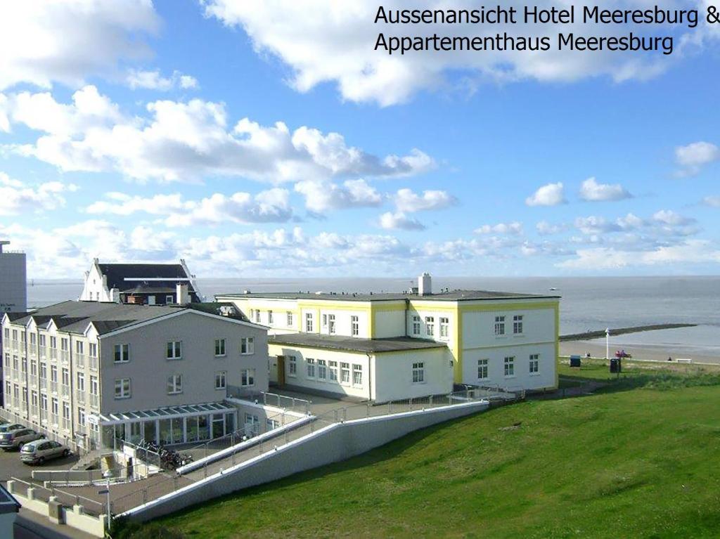 诺德奈Hotel Meeresburg的一组背景海洋的建筑