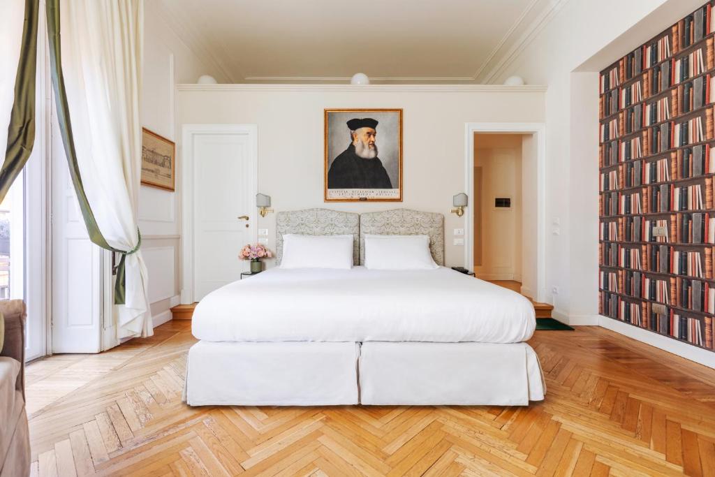罗马雷莱斯唐娜鲁斯西亚旅馆的卧室配有一张大白色床和大画作